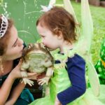 little girl and princess kiss a fake frog